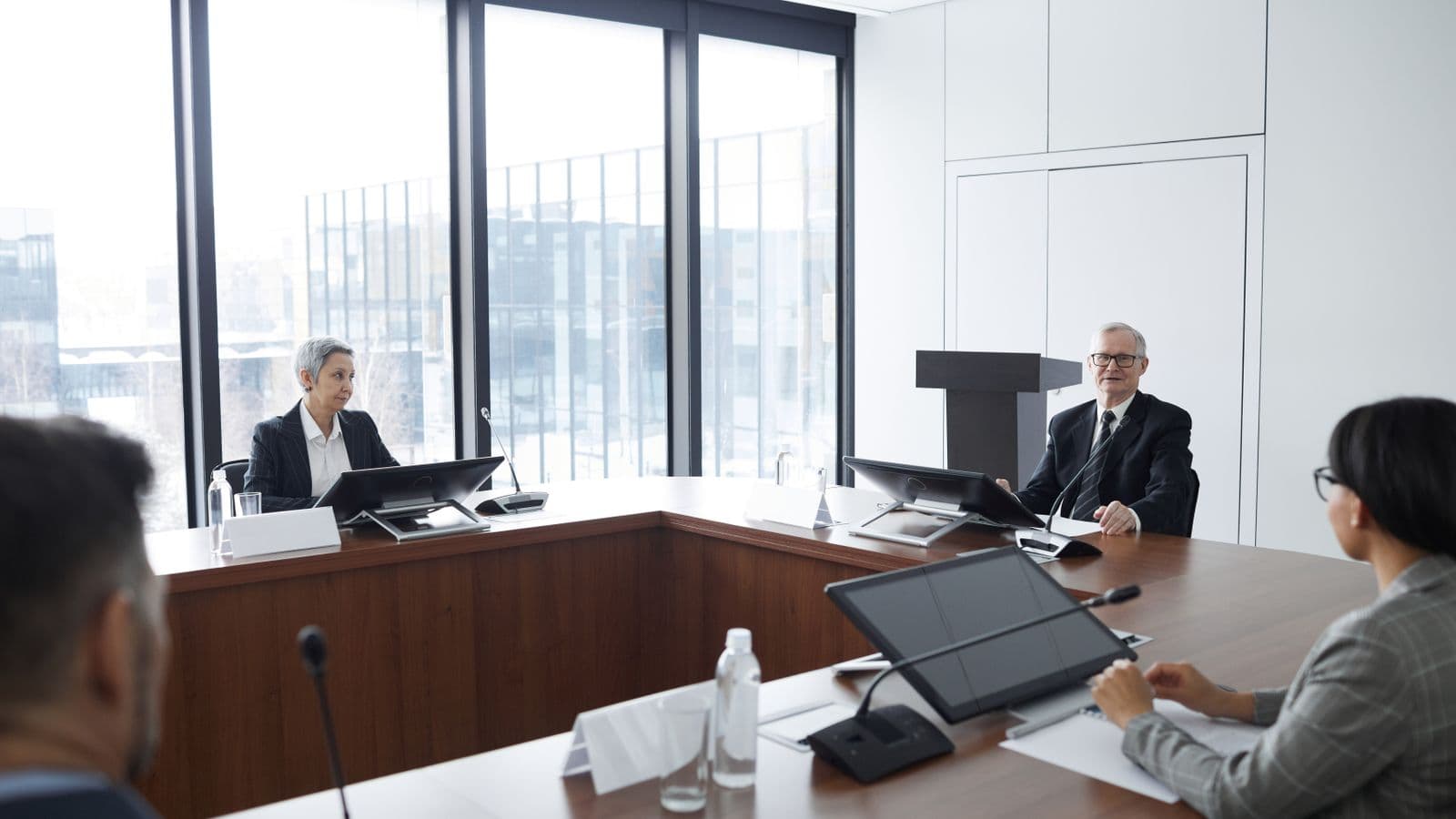 Administrators seated at a formal governing-body table with microphones