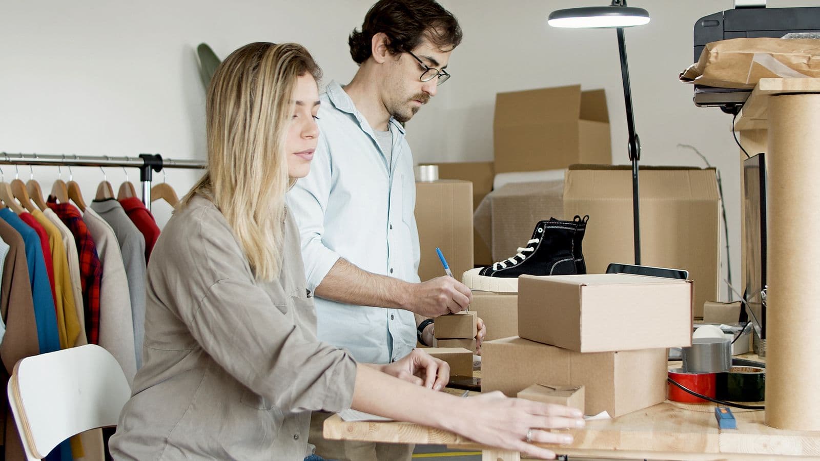 Two small-business owners packing and labelling orders in their studio